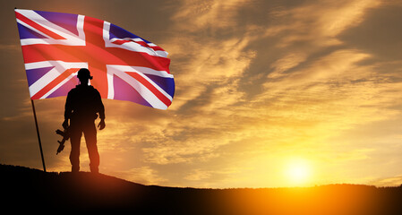 Silhouette of soldier with United Kingdom flag on background of sunset. Greeting card for Poppy Day, Remembrance Day. United Kingdom celebration.