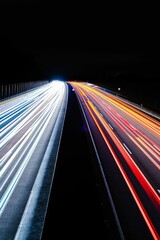 Wall Mural - Vertical shot of long exposure of highway traffic. The car lights draw light trails on night highway