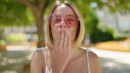 Poster - Young blonde woman smiling confident wearing heart sunglasses at park