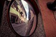 Mirror with the reflection of a narrow street and buildings