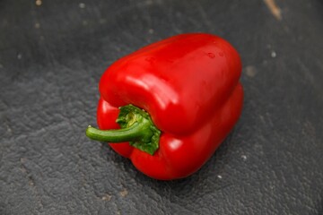 Sticker - Closeup shot of fresh red paprika( bell pepper) on a dark wooden surface