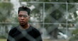 © Marco - Angry young black man looking to camera leaning on metal fence. Upset African American