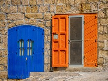 Closeup Of Blue Door And Orange Window On Stony Building In Malta