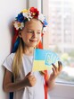 Girl with a flag of Ukraine. Child. Ukrainian child. War. Blue. Yellow. Pray for Ukraine. Ukrainian wreath on the head