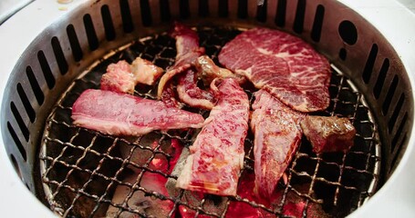 Wall Mural - Close up cooking roast grill tasty delicious Japanese food fresh raw meat beef slice steak on hot charcoal stove with fire flame and smoke for dinner in restaurant, japan premium cuisine yakiniku BBQ