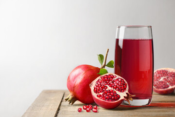 Wall Mural - Pomegranate juice with fresh pomegranate fruits on wooden table.