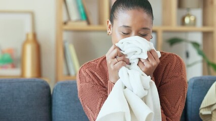 Poster - Lady enjoying the scent of freshly washed clothes after using her favorite fabric softener. Woman smelling fresh laundry while doing housework at home. Female doing routine chores or spring cleaning