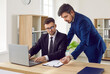 © Studio Romantic - Two business people in suits meet in office, talk, use laptop and work with documents. Man who has some difficulty with interpreting legal agreement is consulting with colleague and asking questions