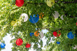 viele bunte Ballons zwischen den Blättern eines Baumes