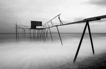 Black And White Long Exposure Shot Tulle Effect Near Coastline With Tiny Wooden Fisherman Pier Abstract Photo 