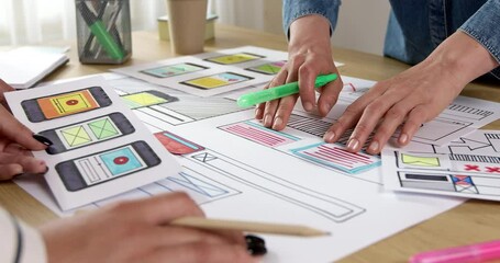 Web designers are developing a smartphone interface. Engineers create sketches of applications for mobile phones. User experience concept.