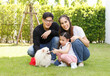 © atitaph - Asian family is happy, bright, cute, daughter is relaxing, playing with the dog in the grass