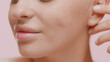 © pavel_dp - Extreme close-up shot of young slim pretty white-skinned woman touches her ear smiling on pale pink background | Sagging jowls prevention concept