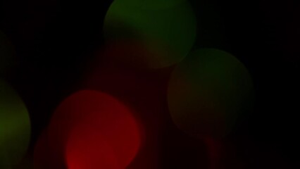 Wall Mural - Christmas bokeh smooth movement on. a dark. Red and Green defocused circles shimmer, shine and sparkle. Can be used as background, overlay or screen for apps. Relaxing New Year's lights motion.