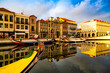 Aveiro, Portugal, Traditional colorful Moliceiro boats in the water canal among historical buildings.