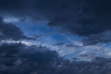 Fototapeta Na sufit - Epic Dramatic storm dark grey cumulus rain clouds against blue sky background texture, thunderstorm