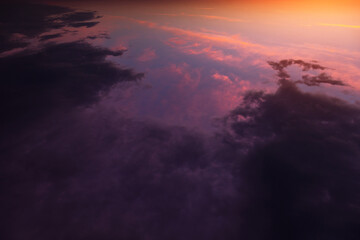 Epic dramatic sunrise above planet earth, storm sky with dark violet cloud, orange yellow sun and sunlight. Sunset view with thunderstorm from space over pink clouds