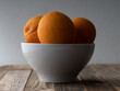 White bowl overflowing with navel oranges