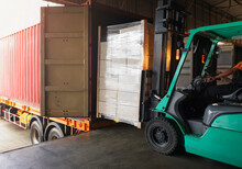Forklift Tractor Loading Packaging Boxes into Shipping Container. Trucks Loading Dock Warehouse. Delivery Cargo Trucks. Distribution Warehouse Logistics. Cargo Shipment. Freight Truck Transport.	
