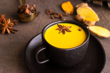 Close up of ayurvedic beverage Golden milk made with tumeric and gignger roots and other spices.