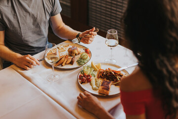 Wall Mural - Young couple having lunch with white wine in the restaurant