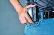 Hand holds pager weighing on belt jeans.