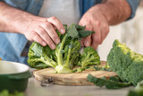 Fototapeta Mapy - Man cooking broccoli in home kitchen. Healthy lifestyle, wholesome food, clean diet eating concept