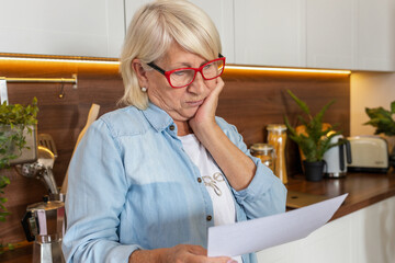 Upset of elderly woman received a utility bill for gas or electricity. Bank loan debt, tax payment concept