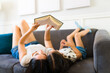 Relaxed mom and kid reading a book during a leisure day at home