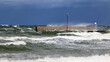 Duża morska fala rozbija się o falochron  na wybrzeżu