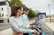 © Kostiantyn - Two young female friends renting bicycle in bike sharing city service for walking