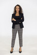 © Danai - Portrait of smart caucasian businesswoman with curly hair in black jacket suite with trousers smiling arm crossed isolate on white background, vertical full body studio shot