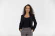 © Danai - Portrait of smart caucasian businesswoman with curly hair in black jacket suite with trousers smiling hands in pocket isolate on white background, horizontal waist up studio shot