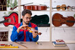 © Elnur - Young man repairing musical instruments at workshop