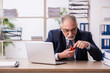 © Elnur - Old male employee smoking pipe at workplace