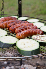 Wall Mural - Sausages and zucchini  being barbequed	