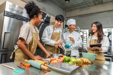 Wall Mural - Students In Cookery Class Mixing Ingredients For Recipe In Kitchen.Male And Female young  Students With chef Teacher Preparing Ingredients For Dish In Kitchen Cookery Class.