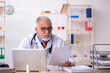 © Elnur - Old male doctor working in the clinic