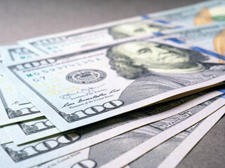 Wall Mural - american paper money. several one hundred dollar bills lie on a gray textured surface. focus on the 