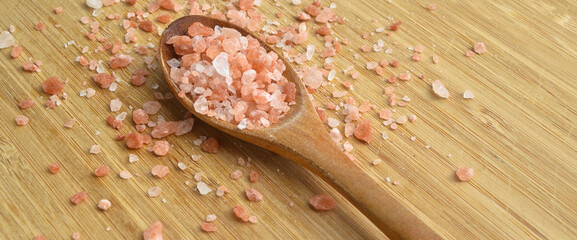 Wall Mural - Pink himalayan salt in wooden spoon on wooden background