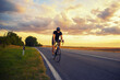 © Solid photos - Young sports man cycling with bicycle on the road in summer