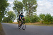 © Solid photos - Young sports man cycling with bicycle on the road in summer
