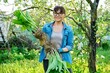 © Valerii Honcharuk - Woman in gardening gloves holding bush of hosta plant with roots for dividing planting