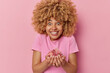 © wayhome.studio  - Happy woman holds delicious sweet jellys in hands smiles toothily glad to eat favorite dessert dressed in casual t shirt isolated over pink background. Cheerful girl eats yummy sugary snack.