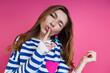 © gstockstudio - Beautiful young woman holding finger on lips while standing against colored background