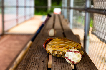 baseball with glove on dugout bench with blurred background