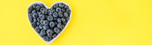 Fresh Picked Organic Blueberries In A Heart Shaped Bowl On A Cheerful Yellow Background, Tasty And Nutritious
