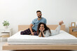 © New Africa - Happy couple on bed with comfortable mattress at home