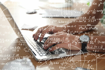 Science and education concept. Illustration of basic physics and mathematics formulas and man working on laptop at table, closeup