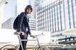 © Art_Photo - Portrait of hipster handsome businessman in suit with backpack walk and hold riding bicycle on the street city way go to work.business travel transport bike concept